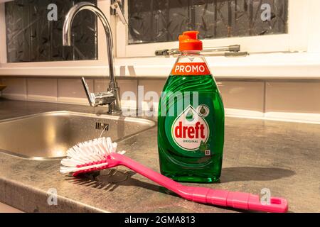 Dishwashing liquid Dreft with dish brush on a kitchen counter Stock Photo