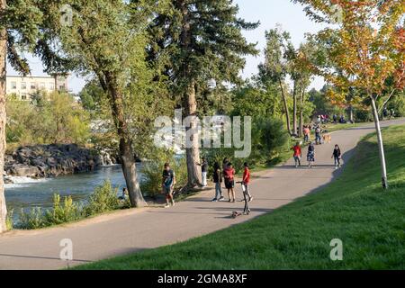 Idaho Falls, Idaho - August 22, 2021: People out enjoying the walking paths and trails near the waterfall and dam Stock Photo