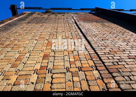 Bottom view orange colored grungy brick wall as background Stock Photo