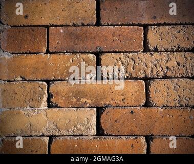 Orange colored grungy brick wall as background Stock Photo