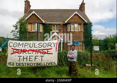 Wendover, UK. 9th September, 2021. Stop HS2 activist Mark Keir stands outside the farm house at Road Barn Farm which HS2 will be demolishing. Today Stop HS2 protesters put banners on the fences of Road Barn Farm now owned by HS2. This was  part of the 9-9-9 National Action Day along the proposed route of the HS2 High Speed 2 railway from London Birmingham. Credit: Maureen McLean/Alamy Stock Photo