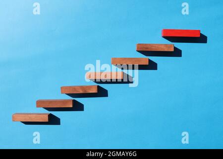 Wooden blocks in form of ladder upstairs red on dove background Stock Photo