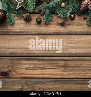 Christmas background with frame of fir branches and balls on wooden background. Blank with a place for text for the festive season Stock Photo