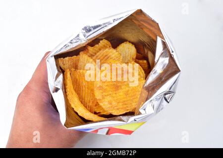 Hand Holding Potato Chips Packet Stock Photo