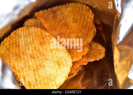 potato chips inside bag, close up, unhealthy food. Stock Photo