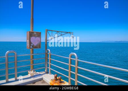 a painted pink heart, seascape seen from the tourist wharf in Versilia, sunny day and cloudless sky, Tuscan Riviera, Tuscany, Italy Stock Photo