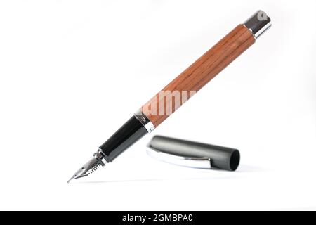 Fountain pen in black and wood with cap isolated with small shadows on a white background, copy space, selected focus and narrow depth of field Stock Photo