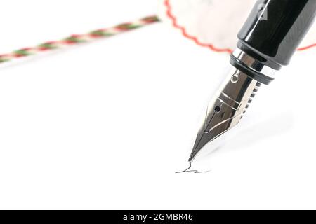 Fountain pen signing a contract next to a seal, white background, copy space, close-up shot with selected focus and narrow depth of field Stock Photo