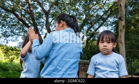 The conflict of the sisters during plays in the garden. The jealousy of the youngest child. Problems in family relationships between children. Stock Photo