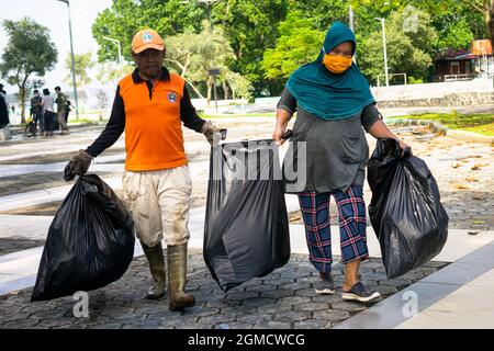 Kendari, Indonesia. 18th Sep, 2021. Garbage collectors carry garbage in bin bags for disposition on world cleanup day.World Cleanup Day is one of the biggest civic movements, uniting 180 countries across the world for a cleaner planet. Credit: SOPA Images Limited/Alamy Live News Stock Photo
