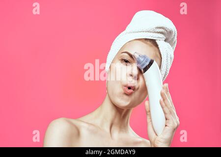 woman with towel on head cleaning skin therapy cosmetics technology Stock Photo