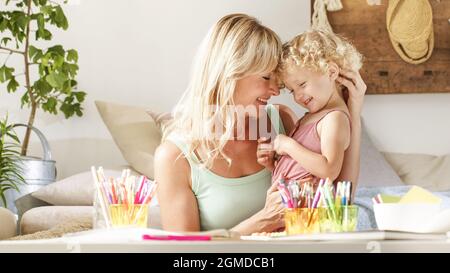 smiling mom hugs her daughter child, preschool learning activities at home, concept of healthy growing, support from caring adults to help develop the Stock Photo
