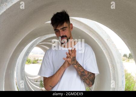 Half-length portrait of a handsome young man inside a large pipe Stock Photo