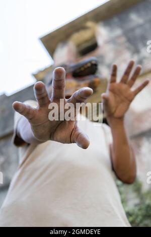 Halloween fear horror concept.Man in lizard mask gesturing with hands at camera Stock Photo