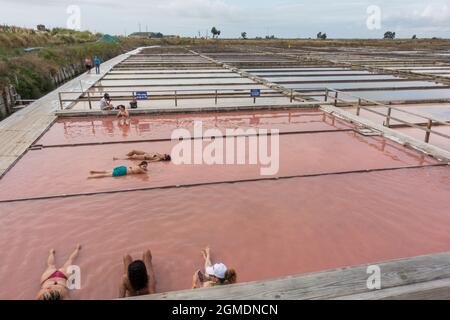 People taking a salt and mud bath in the salt pans of Aveiro, Portugal. Stock Photo