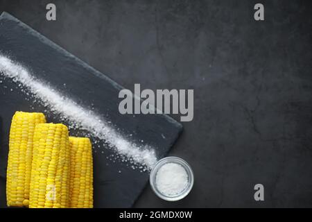 Freshly made fragrant ear of corn with salt. Farm snack fresh corn. Healthy breakfast and healthy lifestyle concept. Stock Photo
