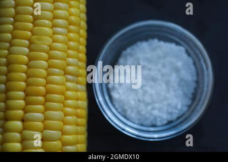 Freshly made fragrant ear of corn with salt. Farm snack fresh corn. Healthy breakfast and healthy lifestyle concept. Stock Photo