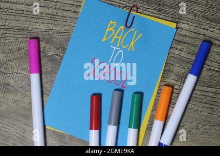 Top view of BACK TO SCHOOL written on colorful notepaper and colorful pen. Stock Photo