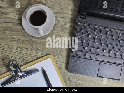 Top view of coffee, laptop, pen and paper clipboard. Copy space for text. Stock Photo