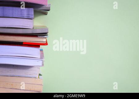 Stack of books on green background with copy space for text Stock Photo
