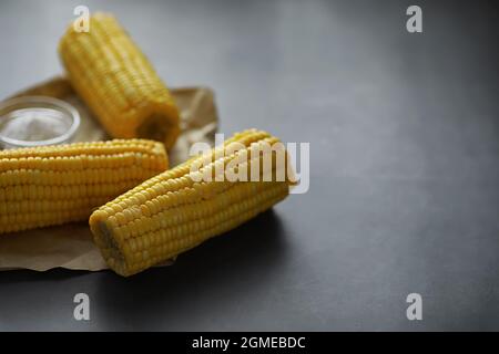 Freshly made fragrant ear of corn with salt. Farm snack fresh corn. Healthy breakfast and healthy lifestyle concept. Stock Photo