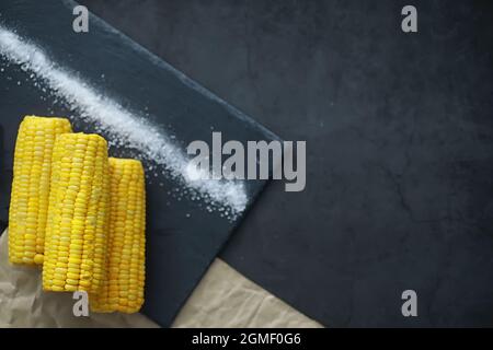 Freshly made fragrant ear of corn with salt. Farm snack fresh corn. Healthy breakfast and healthy lifestyle concept. Stock Photo