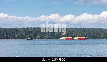 Industrial Tugboat pulling Seaspan Containers Stock Photo