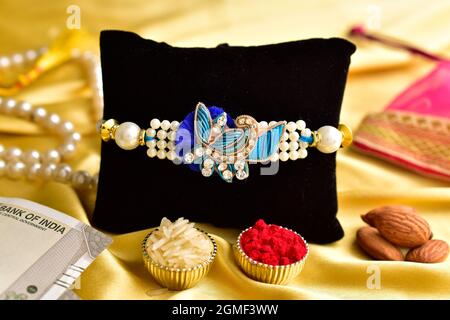 Premium Rakhi with roli chawal on golden background Stock Photo