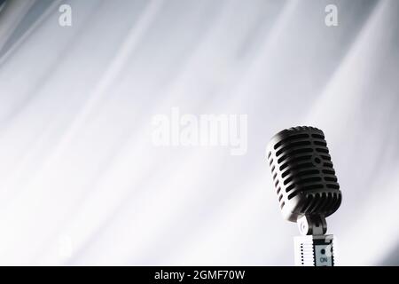 Stand with a retro microphone. Microphone on a tripod. Performance of the artist with vintage microphone. Scene with a microphone. Stock Photo