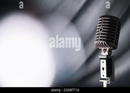 Stand with a retro microphone. Microphone on a tripod. Performance of the artist with vintage microphone. Scene with a microphone. Stock Photo