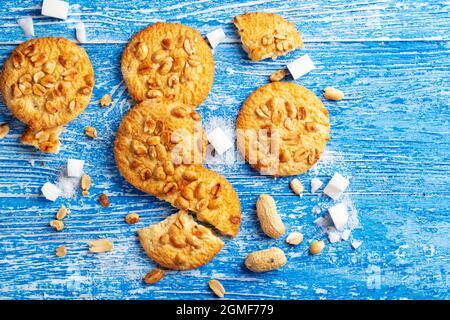 homemade shortcrust pastry sprinkled with peanuts. scattered on a blue wooden background Stock Photo