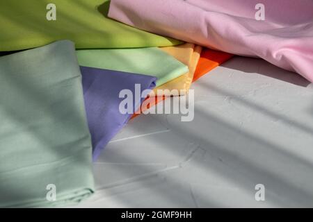 Stack of colorful cotton fabric against grey background, slow fashion and home sewing concept Stock Photo