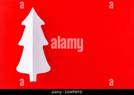Paper Christmas tree on a red background. White paper christmas tree. Christmas minimal concept Stock Photo