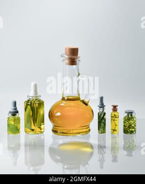Showcase of glass jars with oils indented on herbs. Stock Photo