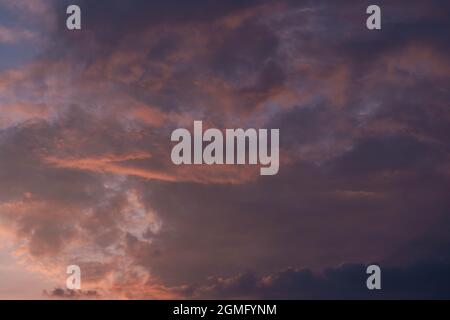 Clouds illuminated by the light of the setting sun. Stock Photo