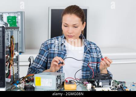 female computer technician using multimeter Stock Photo