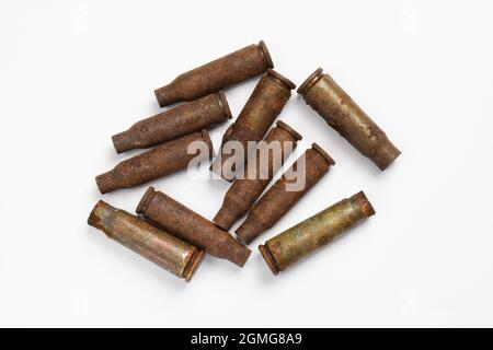 Ten old rusty military shells from a machine gun scattered on a white background Stock Photo