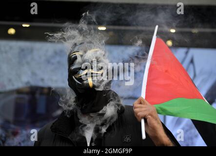 London, UK. 18th Sep, 2021. A protestor wearing a Guy Fawkes holding a Palestinian flag, smoking, during the demonstration.Boycott Puma protest organised by Palestine Solidarity Campaign and FOA (Friends of Al Aqsa) at Puma flagship store on Carnaby Street, London. Activists demonstrated against Puma's sponsorship of the IFA (Israel Football Association). Credit: SOPA Images Limited/Alamy Live News