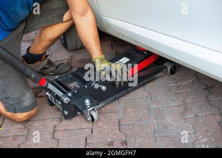 Tire change of a car. placing a jack under the car Stock Photo