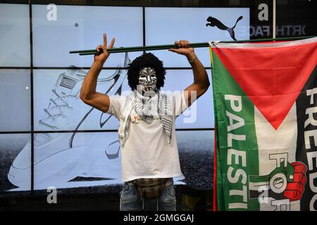 A protestor wearing a Guy Fawkes holding a Palestinian flag, during the demonstration.Boycott Puma protest organised by Palestine Solidarity Campaign and FOA (Friends of Al Aqsa) at Puma flagship store on Carnaby Street, London. Activists demonstrated against Puma's sponsorship of the IFA (Israel Football Association). (Photo by Thomas Krych / SOPA Images/Sipa USA)