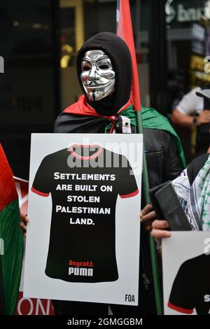 A protestor wearing a Guy Fawkes mask holding a placard, during the demonstration.Boycott Puma protest organised by Palestine Solidarity Campaign and FOA (Friends of Al Aqsa) at Puma flagship store on Carnaby Street, London. Activists demonstrated against Puma's sponsorship of the IFA (Israel Football Association). (Photo by Thomas Krych / SOPA Images/Sipa USA)