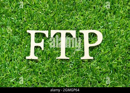 Alphabet letter in word FTP (Abbreviation of File Transfer Protocol) on green grass background Stock Photo