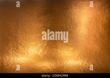 Textured metallic gold background with light and dark highlights, bright and shiny golden metal texture Stock Photo