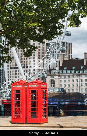 The iconic British red telephone boxes with London Eye wheel in the background, selective focus, no people with copy space. Stock Photo