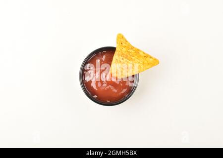 tortilla chips dipped in sauce over white background Stock Photo