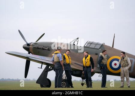 Spirit of Britain living history group stand by a Hawker Hurricane on the flightline during the Battle of Britain Air Show at IWM Duxford. Picture date: Sunday September 19, 2021. Stock Photo