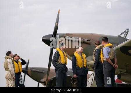 Spirit of Britain living history group stand by a Hawker Hurricane on the flightline during the Battle of Britain Air Show at IWM Duxford. Picture date: Sunday September 19, 2021. Stock Photo