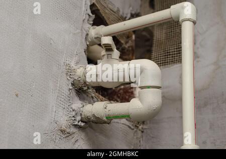 Plastic pipes on the gray wall. Piping with gate valves. Remote Stock Photo