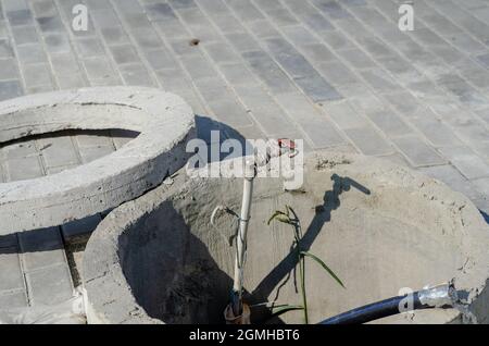 Concrete open sewer manhole at the construction site. Cement wel Stock Photo