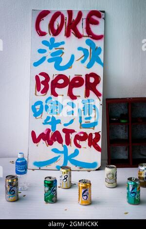 Hand-painted sign advertising drinks for sale by the side of the walking trail from Discovery Bay to Mui Wo in Nim Shue Wan, Lantau Island, Hong Kong Stock Photo